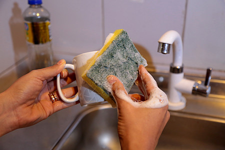 人们在厨房洗碗池中洗碗细菌洗涤剂水槽海绵清洁工卫生家务润滑脂肥皂盘子图片