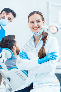 一位自信的女性牙医的肖像 看着摄影机在面具医生药品职业微笑椅子口服蓝色病人男人图片