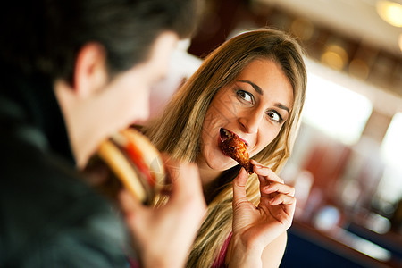 餐厅的一对夫妇吃快餐桌子汉堡成人晚餐乐趣享受微笑夫妻芝士男人图片