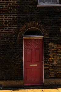 住宅楼的时尚入口 门上方旧砖拱的有趣立面 典型的英国古建筑城市英语窗户行人烟囱寡妇栏杆击剑大街房子图片