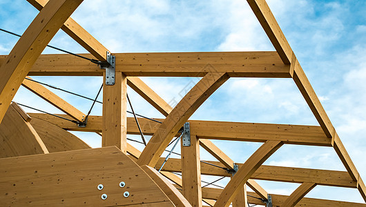蓝色云天空上粘结层状木材的现代木制结构图示细节建造透雕天花板生态木头木板胶合现代性镶板屋顶图片
