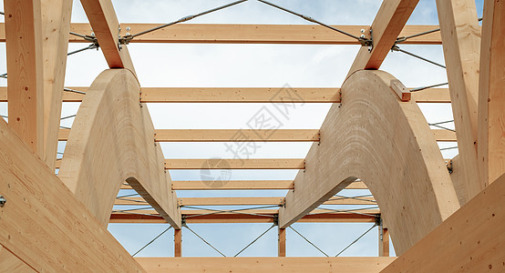 蓝色云天空上粘结层状木材的现代木制结构图示细节胶合控制板现代性镶板木头光束建造木板层压屋顶图片