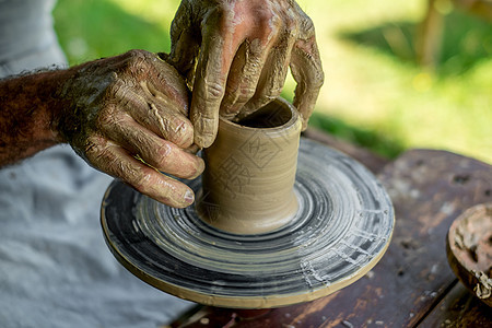 陶器手在陶器车轮上制成粘土锅图片