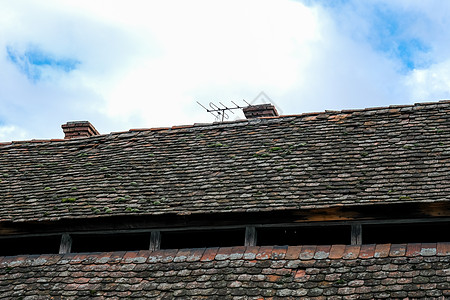 罗马尼亚用砖烟囱和旧电视天线制成的陶瓷屋顶古董卵石建筑学播送建筑黏土材料地衣苔藓制品图片