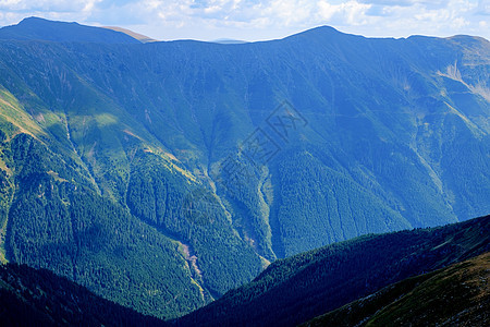 高山山脉风景蓝色爬坡高度远足天空森林首脑国家假期图片