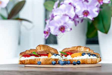 盛满香草奶油 蓝莓 桃子和草莓的黄金烤牛角面包图片