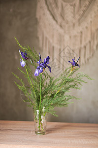 混凝土墙后面的木制桌子上的野花花束图片