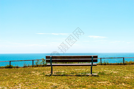 在海边的山丘上空无一席 绿红草植被 木板凳旅行沿海假期海浪地平线木头蓝色晴天孤独场景图片