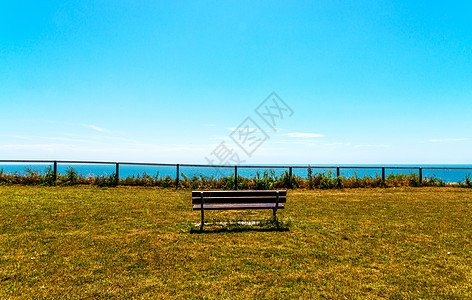 在海边的山丘上空无一席 绿红草植被 木板凳公园支撑海岸线沿海海景地平线场景木头旅行椅子图片