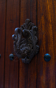 门上装着黄铜敲门的形状 装饰 漂亮的房子入口风格雕塑历史金属木头橡木圆圈青铜风化门把手图片