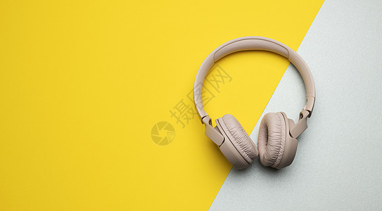 灰黄色背景的粉红色无线耳机 最高视图 现代工具图片