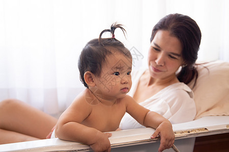 慈爱的母亲和家中新生婴儿的侧面观童年微笑女性女士快乐母性家庭拥抱男生女孩图片