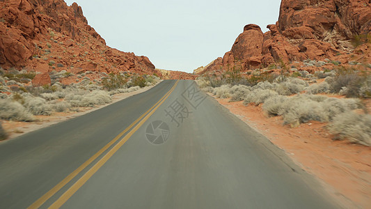 沙漠公路公路旅行 在美国内华达州拉斯维加斯火谷驾驶汽车 在美国搭便车旅行 高速公路旅行 红色外星岩层 莫哈韦沙漠荒野看起来像火星 从车上背景