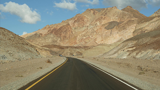前往美国加利福尼亚州死亡谷的公路旅行 在美国搭便车旅行 公路 五颜六色的光秃秃的山脉和气候干旱的荒野 从车上看 内华达之旅汽车视图片