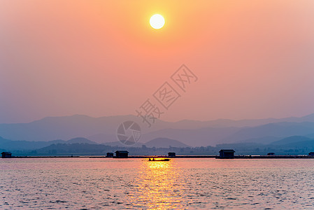 日落时乘船回家的渔民图片