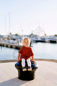 坐在海边船码头上 一个2岁女孩的肖像画图片