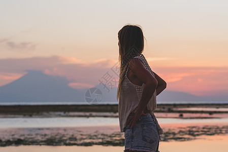 日落时 印度尼西亚隆比克海滩上的金发女孩女性海滩海浪女士海景假期天空反射乐趣工作室图片