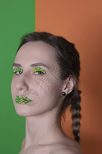 年轻女子肖像 配有糖果化妆品  多彩的糕点 在嘴唇和眼皮上贴珍珠 绿色和橙色的背景 复活节主题女孩焦点选择性食物口红橙子图片