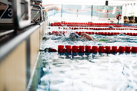 在游泳池比赛中冲向目标的游泳水池游泳衣运动员专注蓝色活力风镜活动中风竞争图片