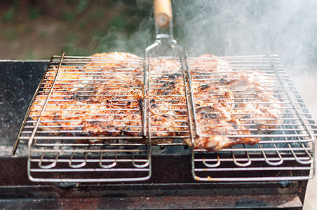 烤鸡大腿在酱汁和香料中被烧焦 用木炭冒出的烟对肉进行加热切除 在露天火炉上炸鸡肉串 营火烹饪季节图片