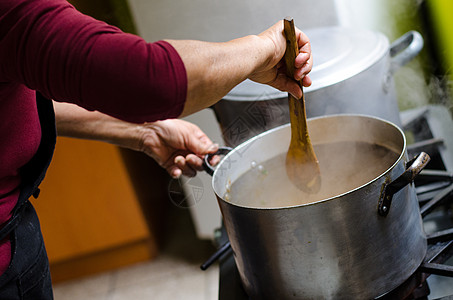 女人的手给锅里加料子食物厨师成人工作女士服务男人平底锅勺子金属图片