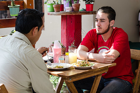 帅哥在户外餐厅吃午餐 男人闲聊纽带男性微笑享受咖啡食物沙拉裁剪时间快乐图片