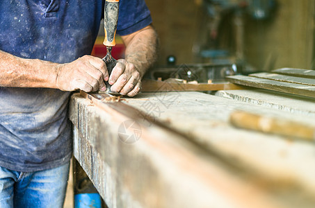 专业木匠在工作 他正在用木工工具雕刻木材 双手紧贴 木工和工艺概念木制品工作台剃须技巧体力劳动手工工匠男人芯片锯末图片