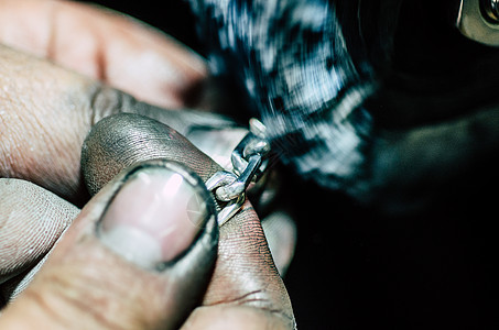 珠宝商在他的工作坊里 在银链上工作指甲棕榈手工戒指工作台生产烧伤钻孔金子铁匠图片