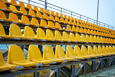 小型运动场讲台上的黄色塑料座椅民众部门剧院团体椅子扇子展示会场看台建筑学图片