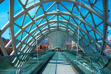 第比利斯库拉河上由玻璃和金属人行桥制成的现代时尚设计建筑学和平首都街道蓝色建造中心反射旅游地标图片