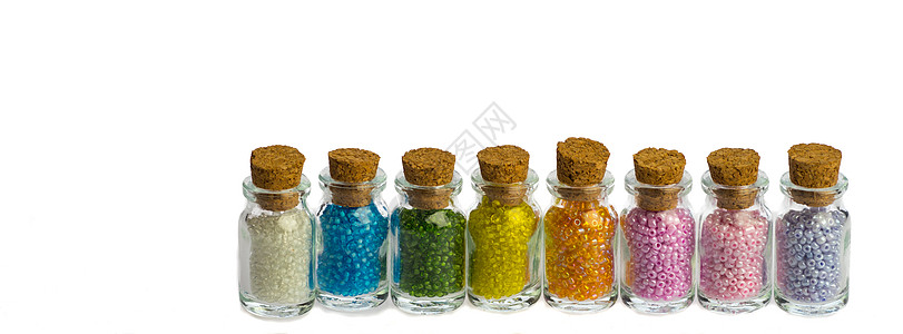 一连串的小瓶子 带着色彩多彩的珠珠 孤立在白色背景上图片
