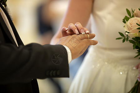 婚礼仪式 新娘的手把戒指戴在新郎的手指上 结婚戒指男人成人男性婚姻套装裙子金子女性女士珠宝图片