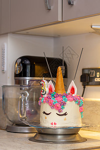 厨房角的独角兽蛋糕装饰烹饪派对用具静物生日混合器蜡烛烘烤甜度图片
