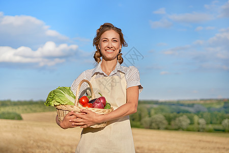 女农民围裙站在农田微笑收获篮子土地洋葱女性企业种植园生长收集专家图片