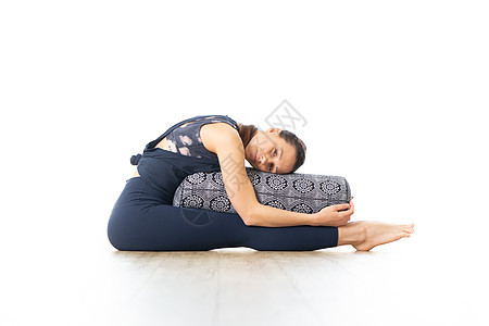 带垫子的恢复性瑜伽 年轻的运动美女在亮白色的瑜伽工作室里 躺在垫子上 在恢复性瑜伽中伸展和放松 健康积极的生活方式身体保健健身房图片