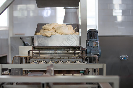 由酵母面团制成的面包制品工业线 后方是营养面粉包子产品糖果作坊糕点工厂自动化运输车图片