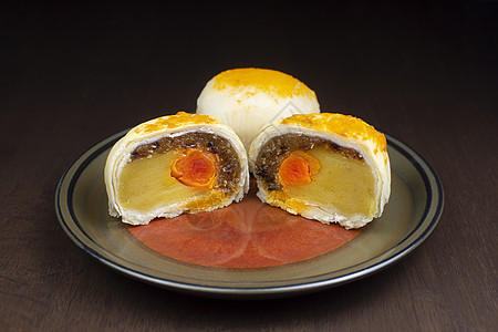 月亮蛋糕 中国糕饼 在木制桌上盘子上加咸蛋烹饪美食甜点庆典文化面包桌子节日传统糕点图片