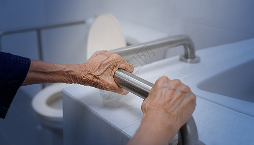 在卫生间扶手扶手的老年妇女退休帮助浴室病人女士安全照顾者理疗医院皱纹图片