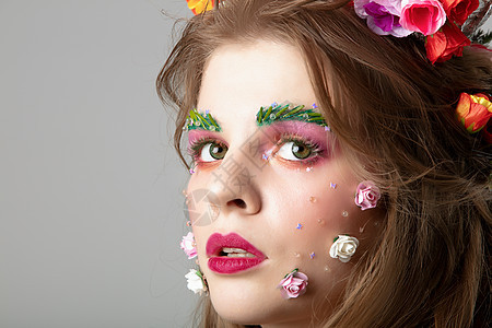 一个有创意的化妆的漂亮女孩的画像 夏天女孩 鲜花盛开的豪华模特的脸 天然化妆品概念图片