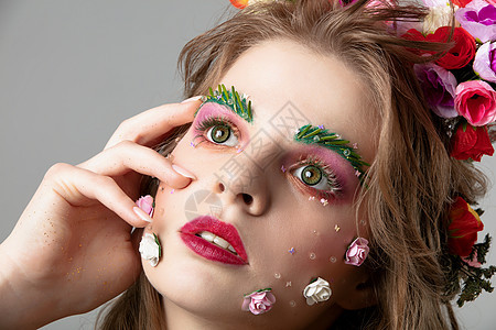 一个美丽的女孩与春天化妆的画像 夏天女孩 鲜花盛开的豪华模特的脸 眉毛和睫毛延伸的概念图片