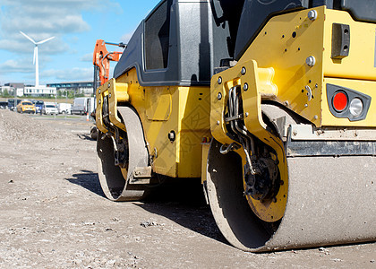 在道路工程和新的人行道建设期间 在新铺设的柏油布上安装滚筒机器工业工作运输力量挖掘机卡车黄色车辆图片
