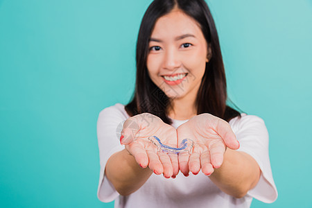 妇女笑着拿着硅酮或口服牙膏 手掌上的牙齿牙医女士卫生女孩保留者女性牙科口腔科治疗支撑图片