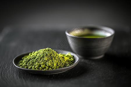 Matcha 粉红绿茶饮料美食盘子黑色粉末粉状芳香绿色背景