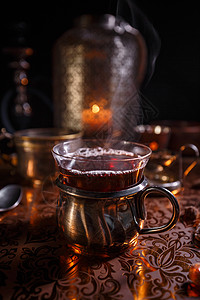 杯子和蜡烛中的黑茶芳香茶碗茶壶香气生活黑色作品饮料仪式玻璃背景图片