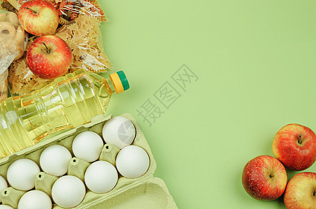 与拷贝空间的捐赠食物绿色背景 平躺 顶视图 模拟 大米 罐头食品 黄油 鸡蛋 苹果 意大利面 食物捐赠或食物递送概念 检疫期间的图片