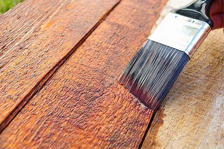 户外木材表面密封剂画笔应用特写-u图片