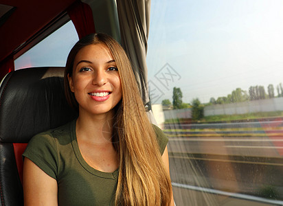 坐在公共汽车上微笑着的年轻美女图片