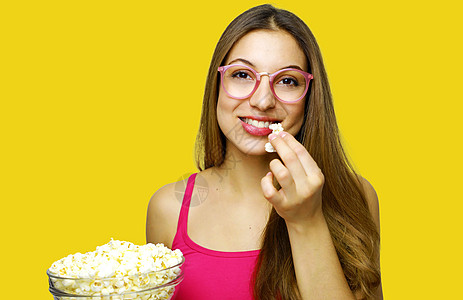 年轻美女拿着爆米花碗小吃女性手表爱好广告流行音乐连续剧食物惊奇乐趣图片