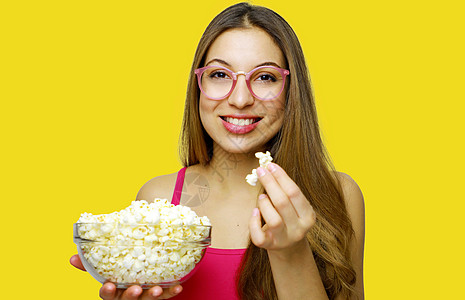 年轻美女拿着爆米花碗惊奇情感观众享受女性学生流行音乐快乐食物玉米图片