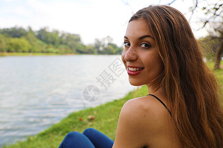 年轻美女放松并坐在巴西圣保罗Ibirapuera公园图片